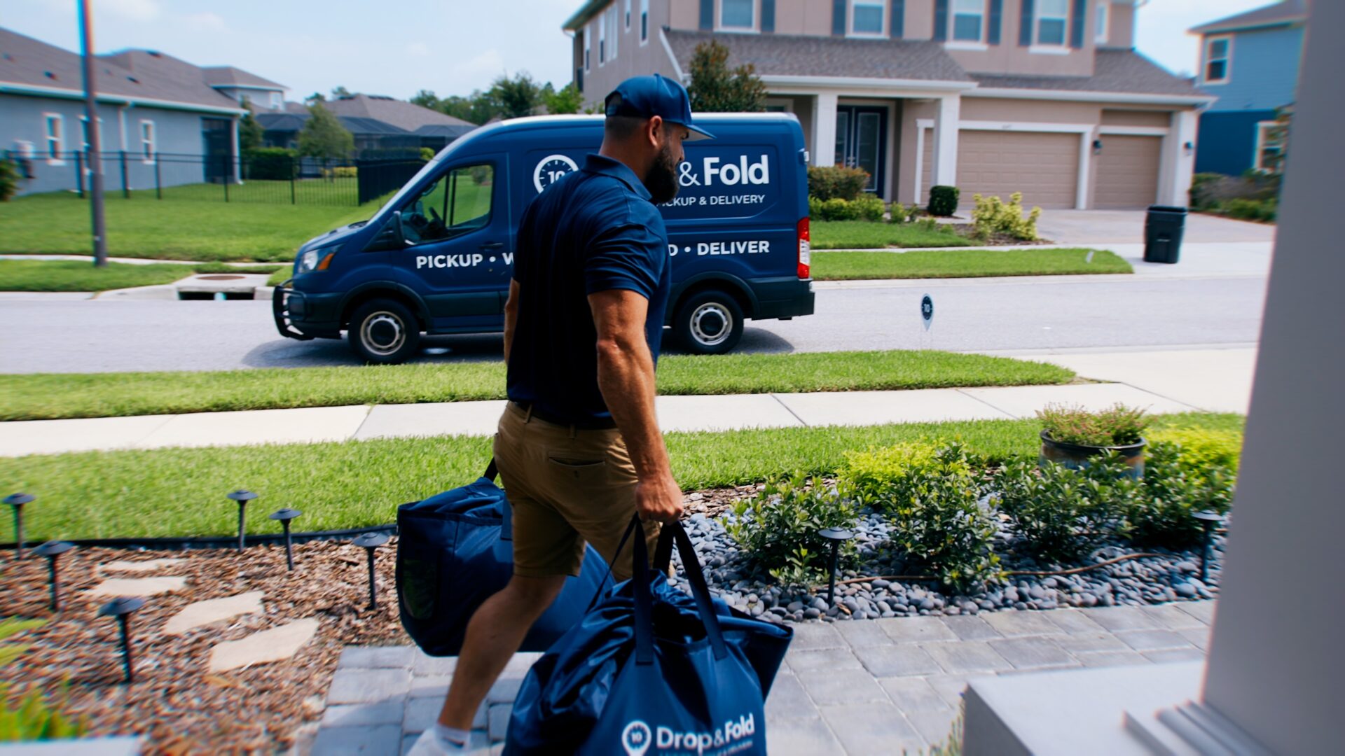 A Drop & Fold Laundry driver delivering folded laundry to a customer's front door